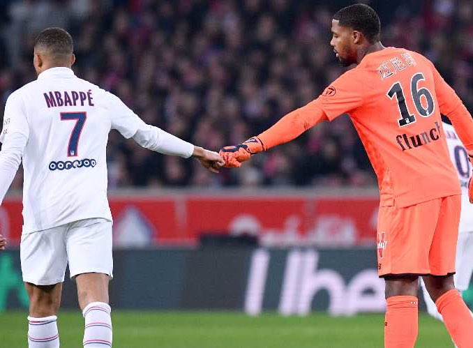 L-R: Kylian Mbappe holding hand with Mike Maignan