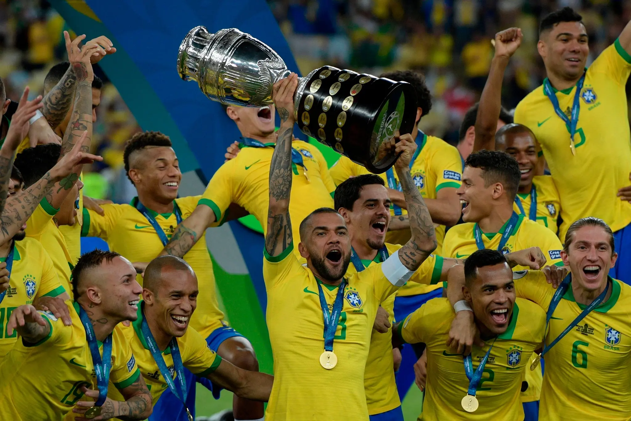 TOPSHOT - Brazil's Dani Alves (C) and teammates celebrates with the trophy after winning the Copa America after defeating Peru in the final match of the football tournament at Maracana Stadium in Rio de Janeiro, Brazil, on July 7, 2019. (Photo by Juan MABROMATA / AFP) (Photo credit should read JUAN MABROMATA/AFP via Getty Images)
